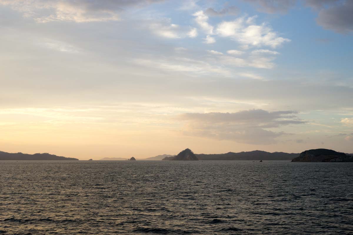 Photo of the sea with mist covering the rocky formations near the shore.